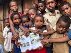 Children holding printed Bible stories