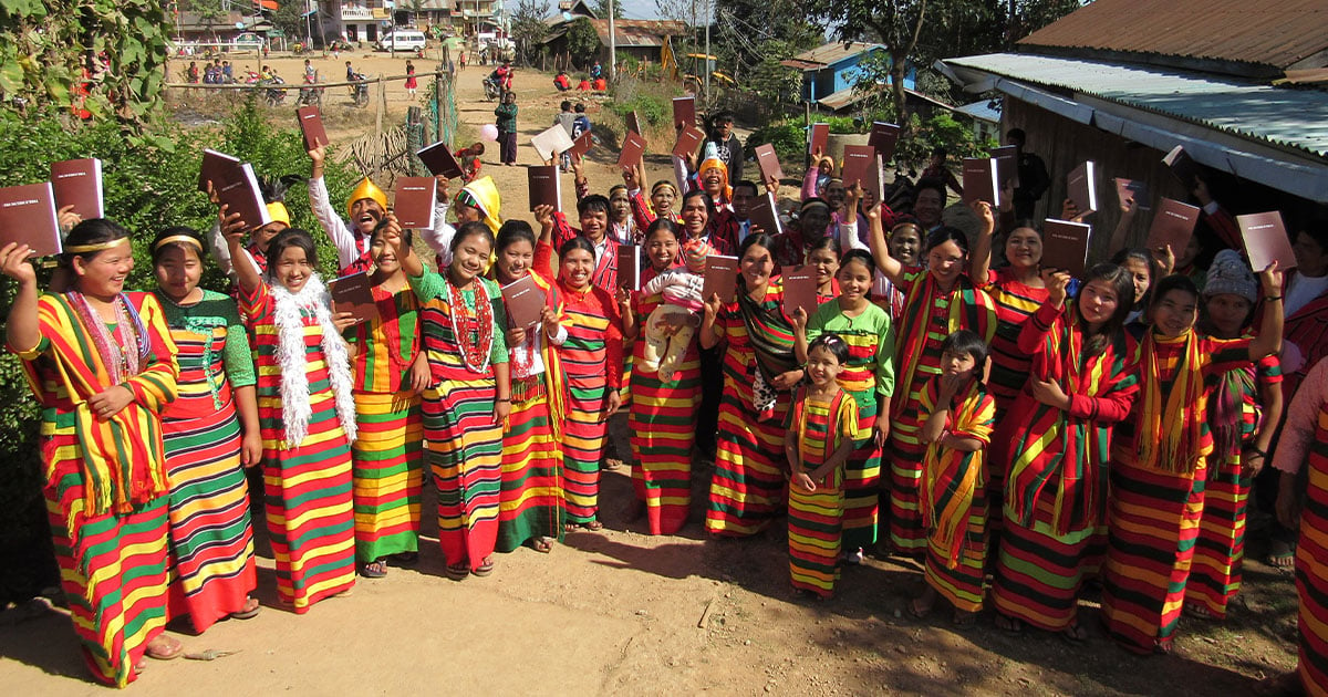 Colorfully dressed crowd of women holding new Bibles
