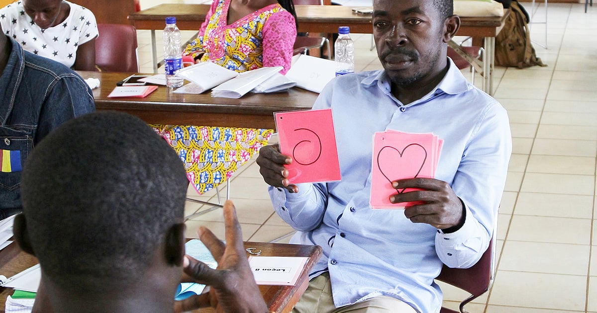 A man with flashcards showing SUN symbols