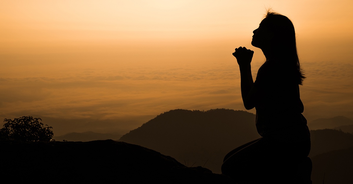 A woman kneeling and praying