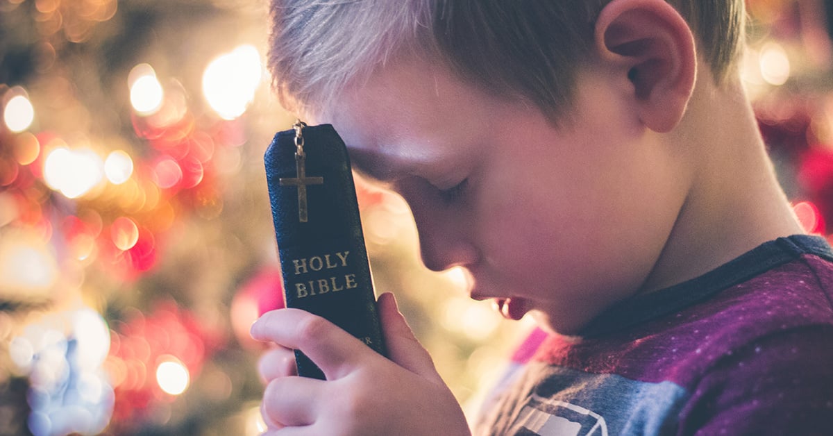 boy-with-bible-praying-1200x628-wycliffe-associates | accelerating-bible-translation