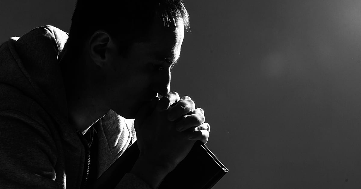 man prays with Bible 1200 x 628